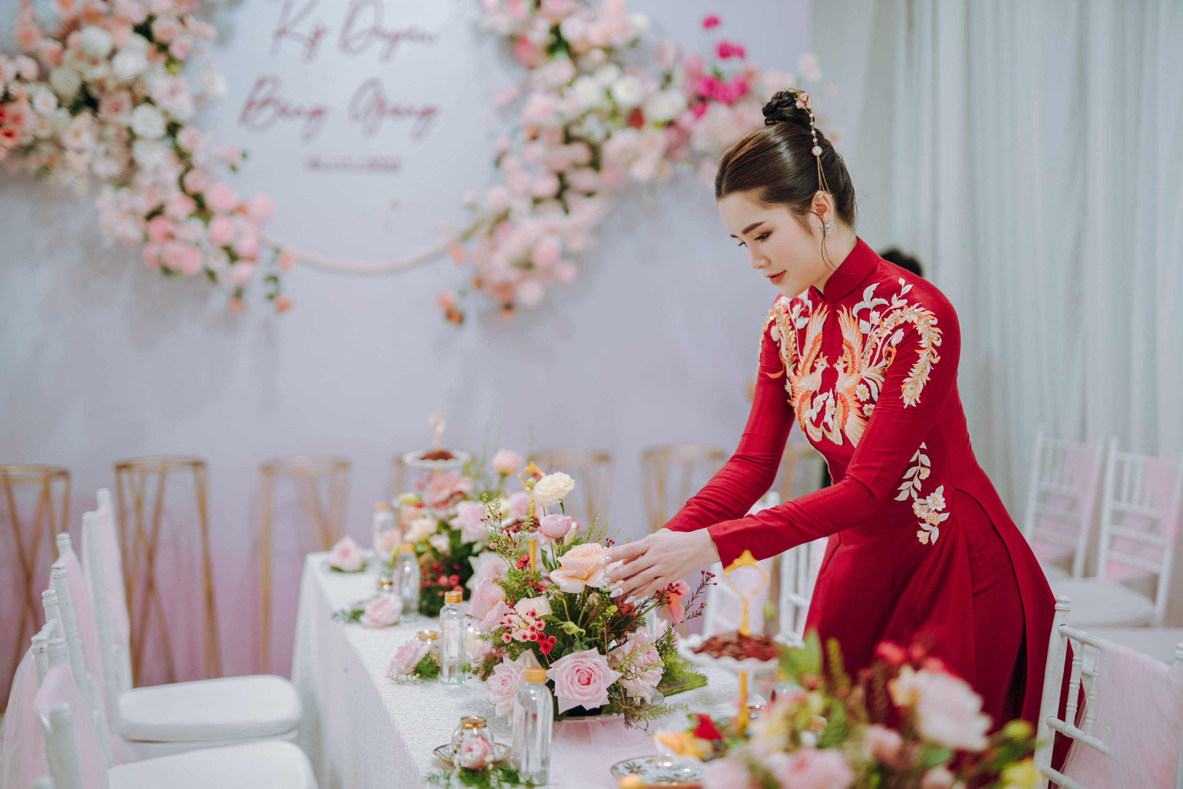 Mariée vérifiant la décoration florale de la table le jour J