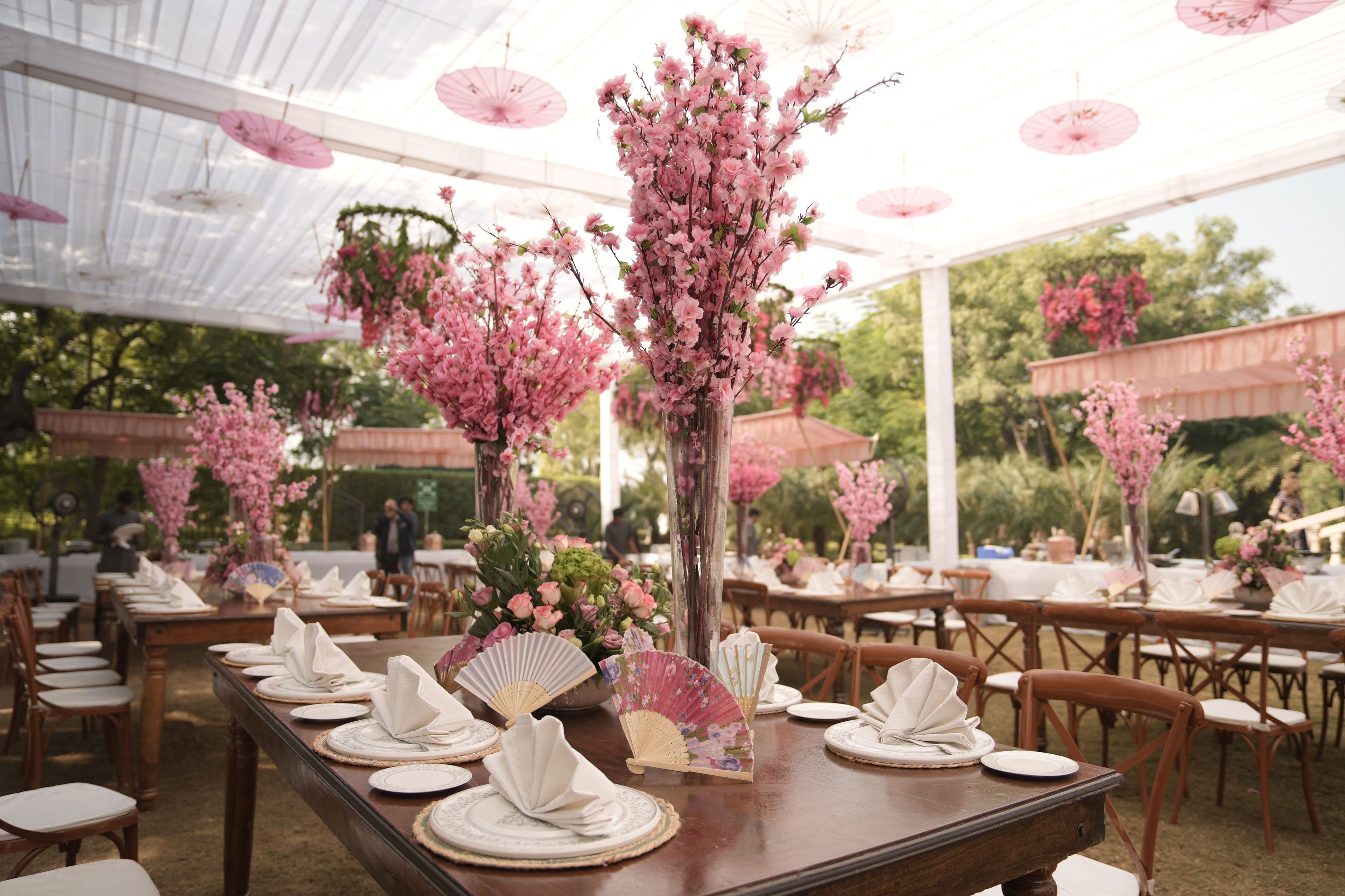 Tables de réception de mariage décorées de branches fleuries et d'éventails