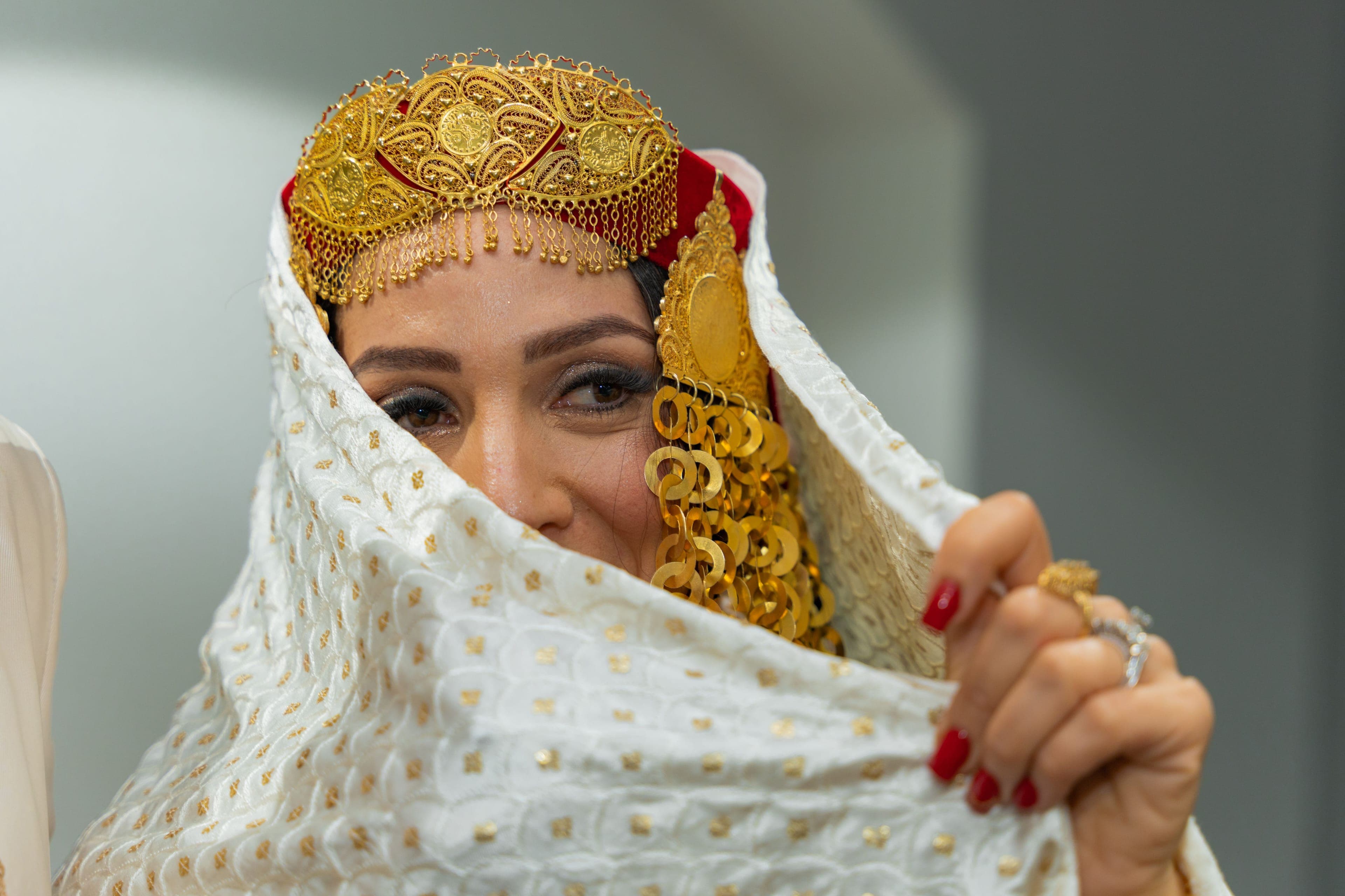 Mariée en tenue traditionnelle ornée de bijoux dorés lors d'un mariage franco-algérien