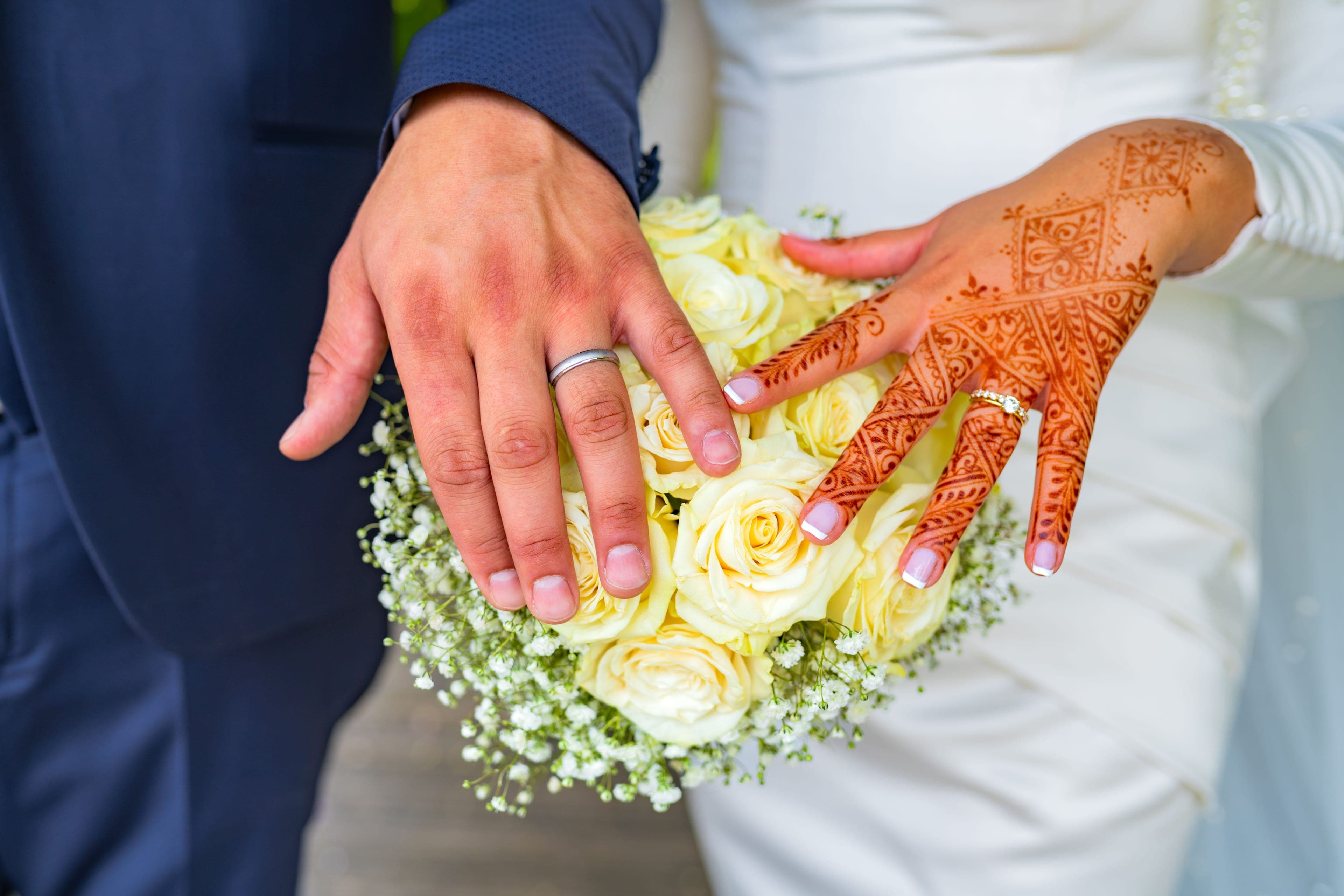 Mains des mariés sur le bouquet, la mariée ornée de henné, mariage franco-maghrébin
