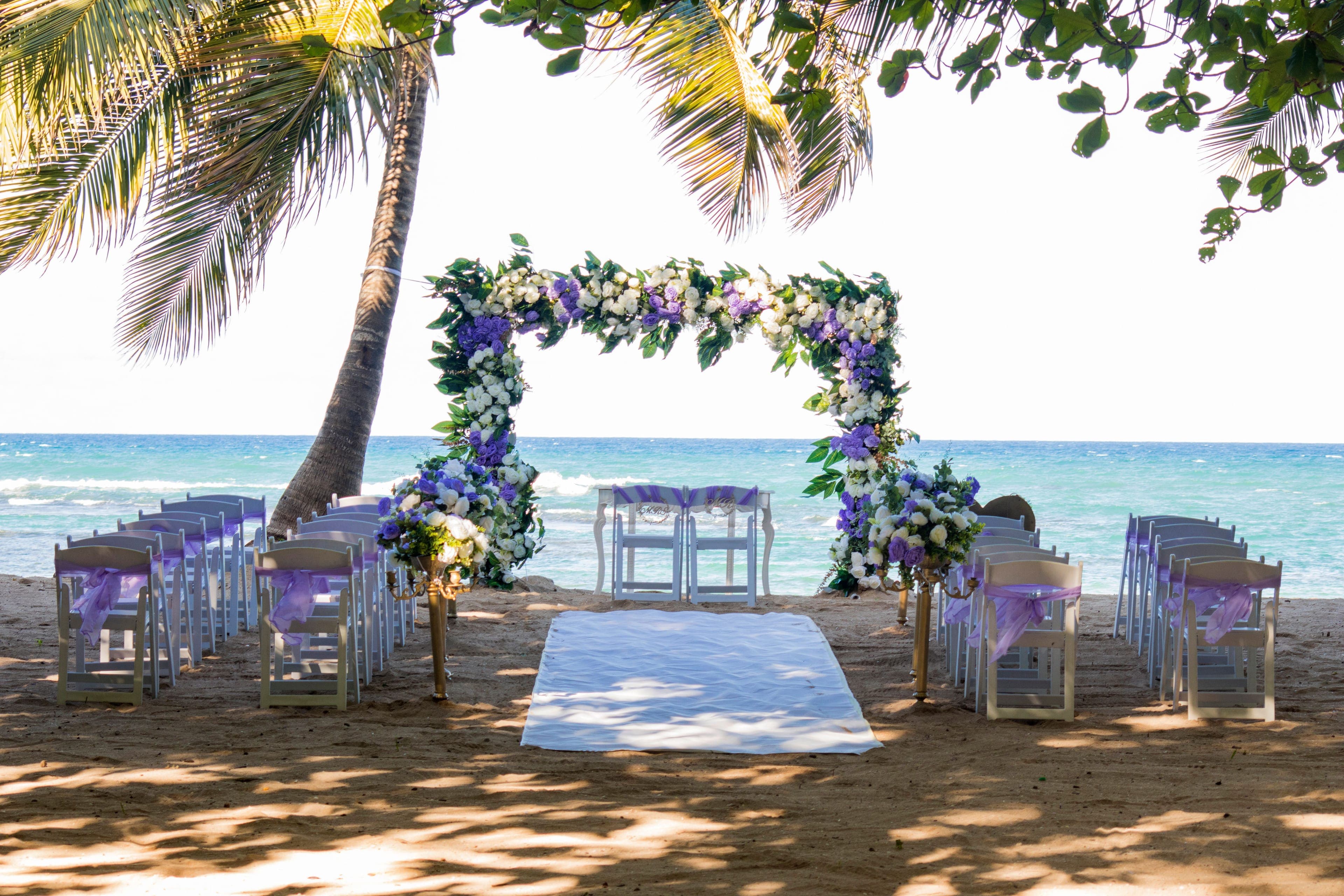 Cérémonie de mariage sur une plage des Caraïbes avec arche fleurie
