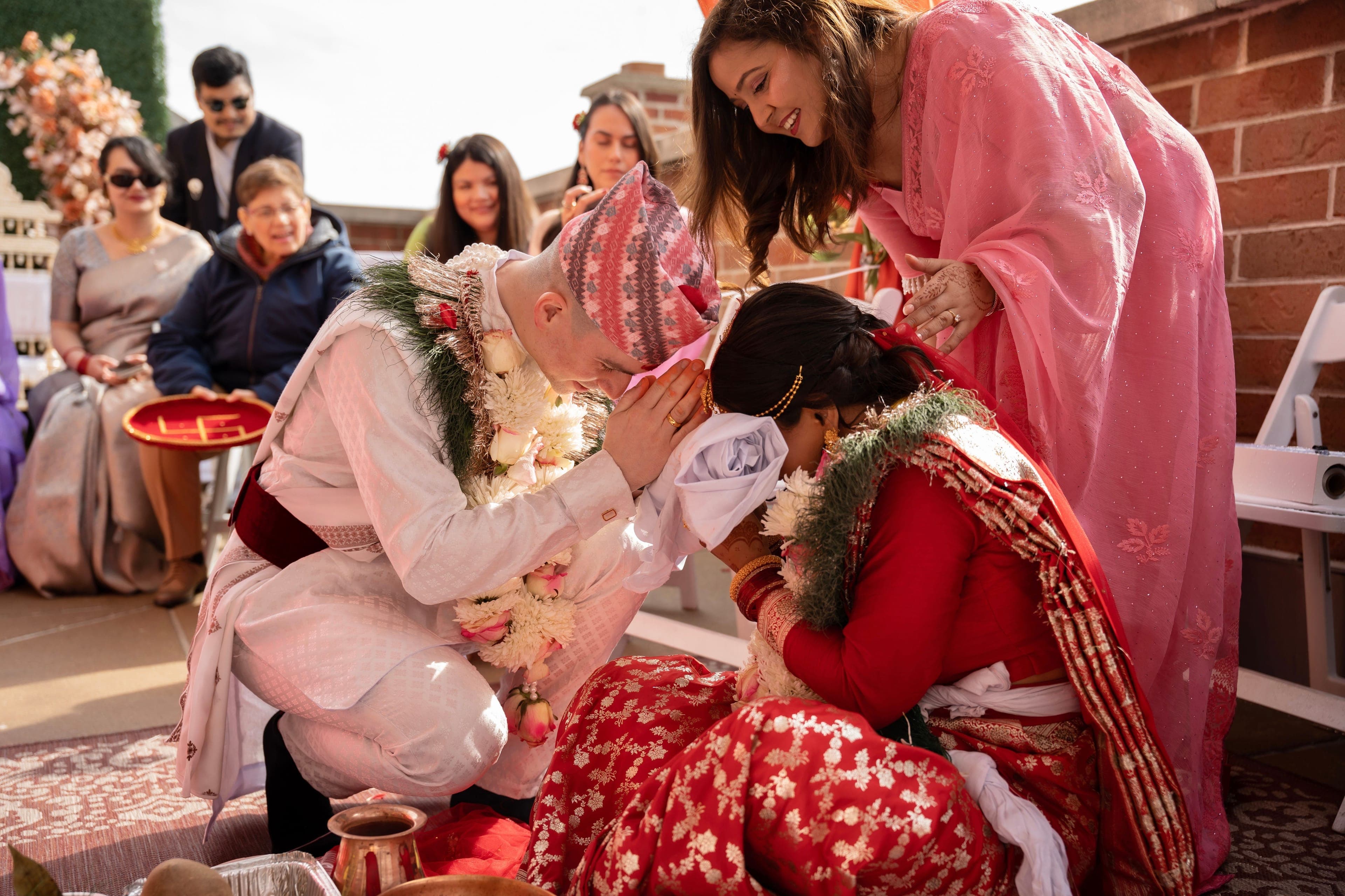 Mariés recevant la bénédiction de leurs familles lors d'un mariage multiculturel