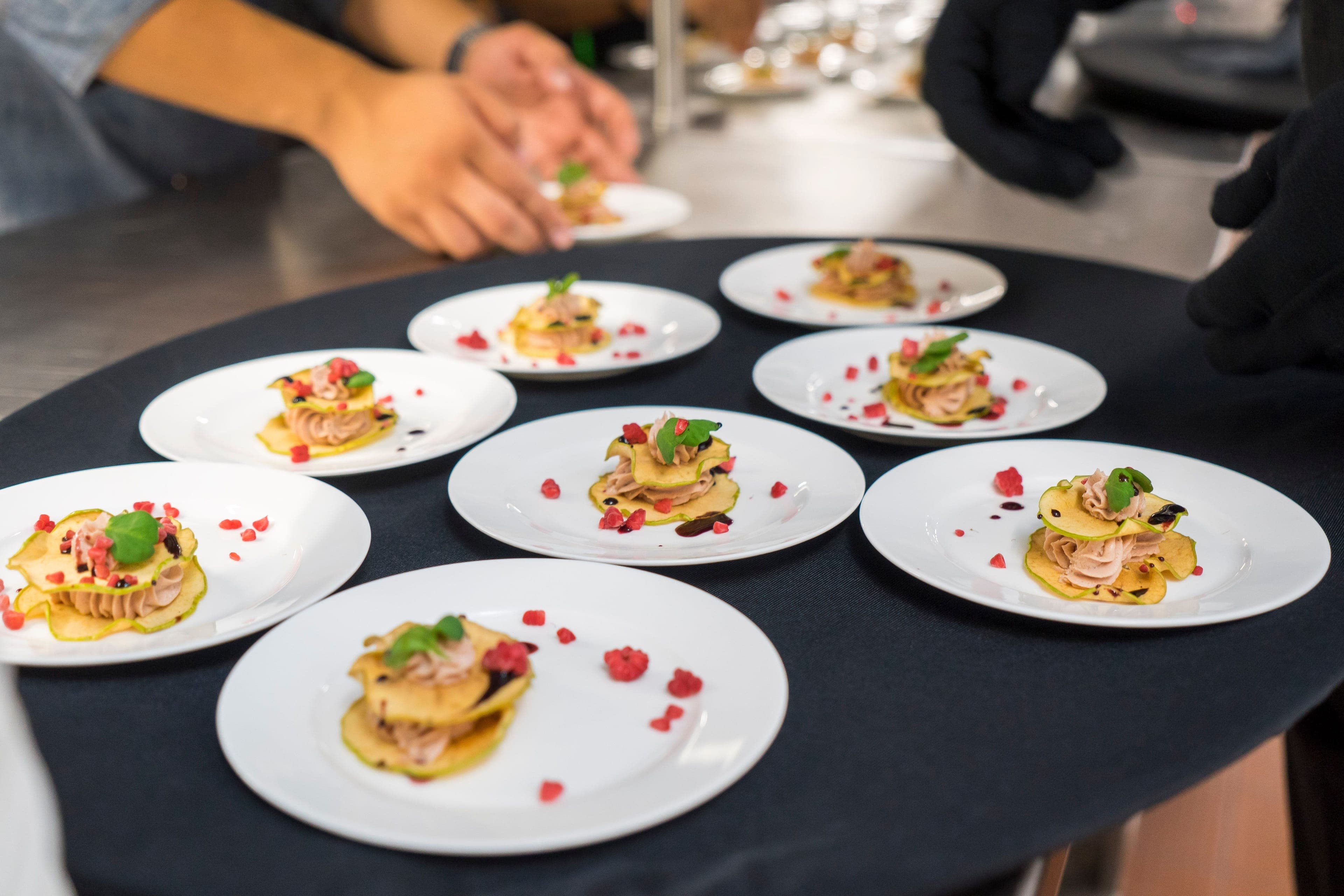 Assiettes d'entrée dressées une à une par l'équipe d'un traiteur avant le service